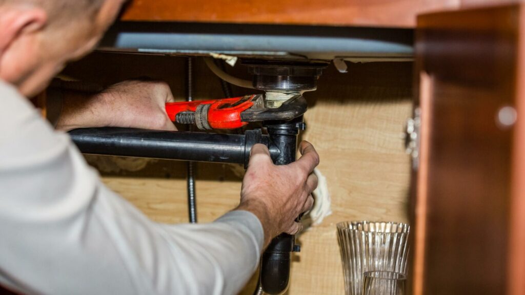 A Plumber Reparing Pipes in a Home