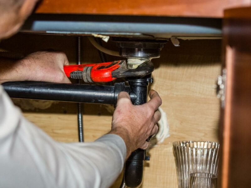 A Plumber Reparing Pipes in a Home